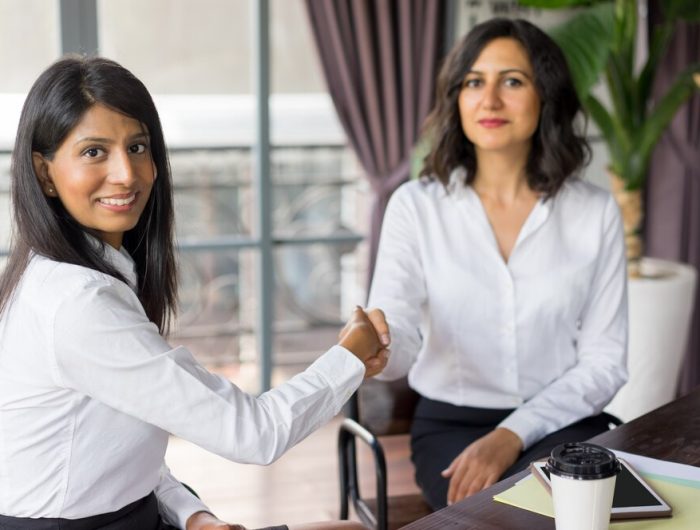 portrait-successful-female-partners-shaking-hands_1262-12463